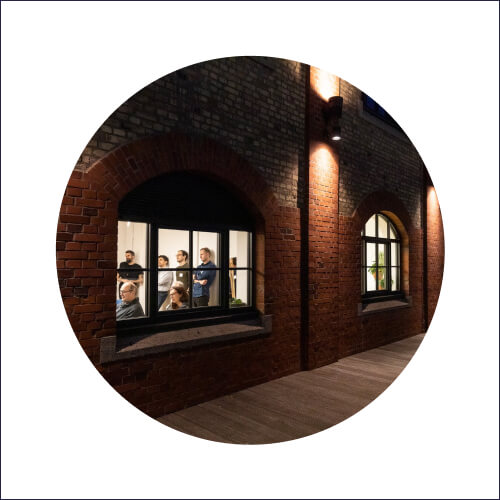 Beim Blick von außen durch ein Fenster, sieht man Teilnehmer des BarCamps Innovation Culture Camp